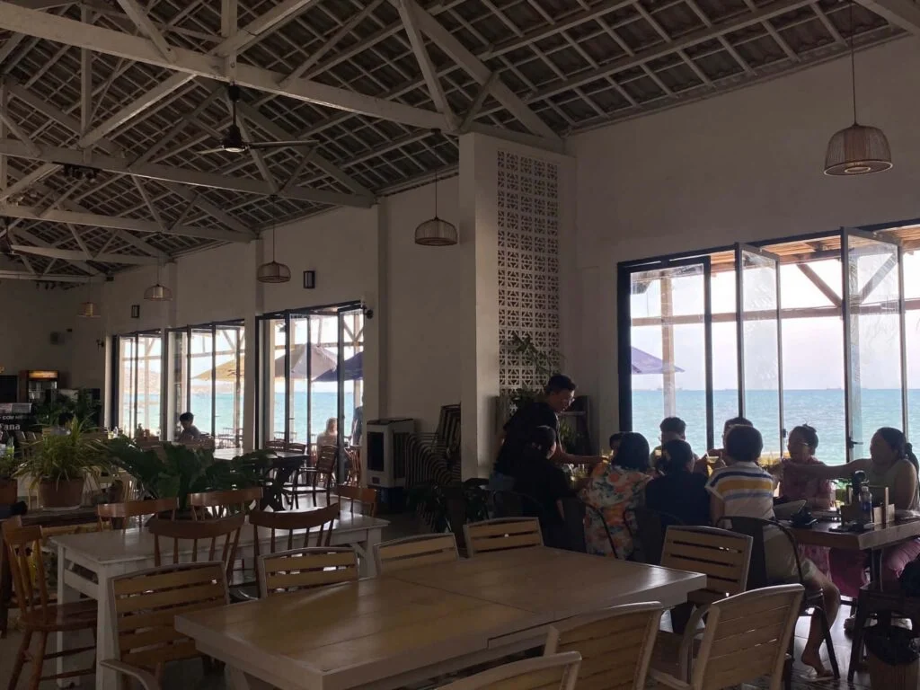 Airy seaside dining hall full of guests